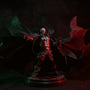 Black fabric wire-frame cape with flame-like torn edges draped over a Spawn-style action figure torso, displayed on a pedestal against a gothic fog backdrop with red spotlight.
