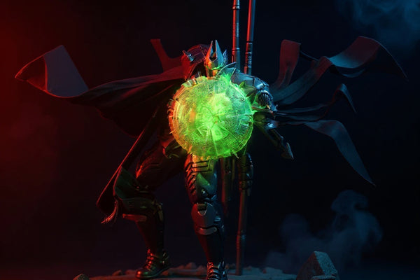 Dark fabric cape on action figure with wire folds and red trim, posed mid-action against moody rubble diorama with red and blue LED lighting.