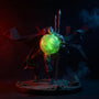 Dark fabric cape on action figure with wire folds and red trim, posed mid-action against moody rubble diorama with red and blue LED lighting.