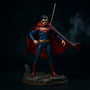 Dark flowing fabric cape with wire outline draped over action figure torso, dramatic windswept pose, gothic diorama backdrop with fog and ruined cityscape, dramatic side lighting.