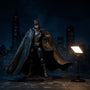 McFarlane Batman figures with fabric capes displayed on a rooftop diorama with a glowing Bat-Signal against a Gotham skyline backdrop, lit with moody blue light.