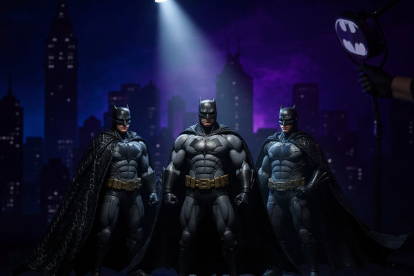Batman Ultimate Movie Collection 6-pack action figures displayed on a miniature Gotham City skyline backdrop with Bat-Signal spotlight, dramatic blue and purple lighting.
