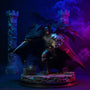Dark charcoal matte fabric cape with wire-frame ridges draped over medieval-armored Batman action figure against gothic castle backdrop with blue purple LED fog.