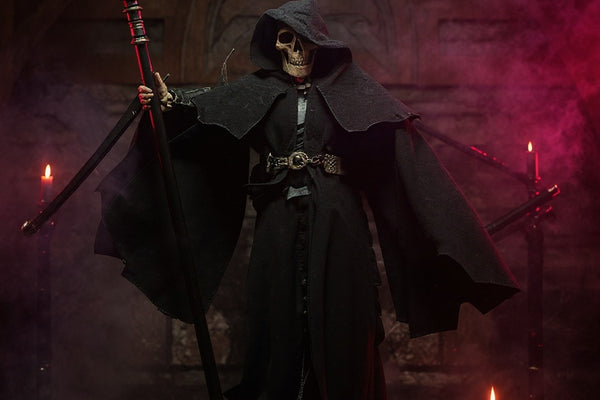 Dark textured fabric cape with wire support draped on a stand amid gothic props under dramatic red-purple lighting.