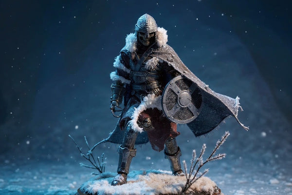 Tattered frost-textured cape on skeleton figure in snowy diorama with bold blue gradient background.
