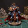 Deep red fabric cape with wire-shaped flowing edges draped over a 1/18 scale action figure armor torso on a miniature battle diorama base with rubble, moss, and weapon props.