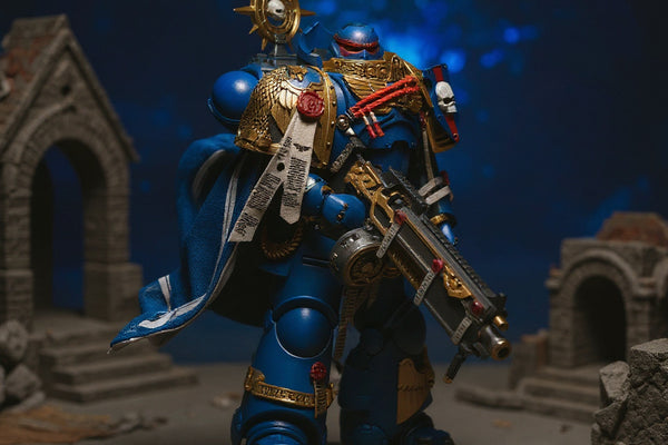Handmade deep blue cloth cape with gold trim and parchment purity seal draped over a 1/18 action figure shoulder, posed dynamically on a miniature battlefield diorama with rubble and bolter rifle, dramatic blue and gold lighting.