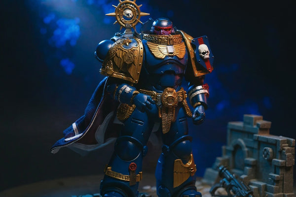 Deep blue action figure cape with gold trim and purity seal draped over shoulder on battlefield diorama, dynamic pose.