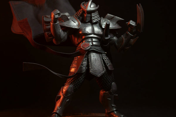 Black fabric cape on miniature Shredder figure against red and black ninja backdrop