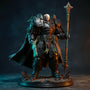 Dark grey-green weathered cape with wire-posed draping on a 1/18 scale armored figure, against a teal-to-orange gradient backdrop, dramatic lighting.