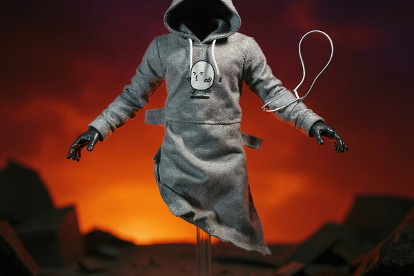Grey hooded cloth top for 1/12 figures posed on a stand in a ruined city diorama with dramatic spotlight and gradient sky.
