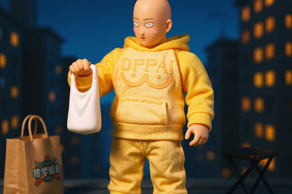 Soft fabric yellow 1/12 scale jumpsuit on bald superhero action figure in urban rooftop diorama with grocery bags, slippers, and stool.