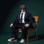 Miniature school uniform outfit draped over wooden desk and chair in a bold classroom diorama, dramatic lighting.