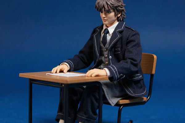 Miniature school uniform set on a 1/12 figure seated at a wooden desk in a diorama classroom with bold blue background.