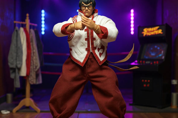 Handmade soft cloth costume with bendable wire hems draped on a tiny mannequin stand in a miniature dojo, surrounded by neon-lit arena props, fabric swatches, and sewing spools, against a bold blue to magenta gradient background.