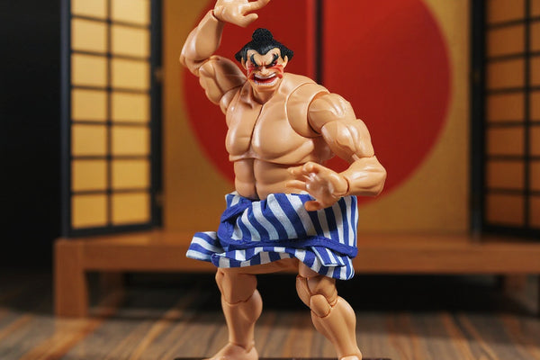 Small blue cloth mawashi belt on 1/12 scale action figure torso displayed on miniature sumo ring with salt scatter and folding screen