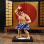 Small blue cloth mawashi belt on 1/12 scale action figure torso displayed on miniature sumo ring with salt scatter and folding screen