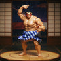 Blue cloth mawashi belt on a 1/12 scale action figure torso displayed on a miniature sumo ring platform with a Japanese folding screen in the background under dramatic lighting.
