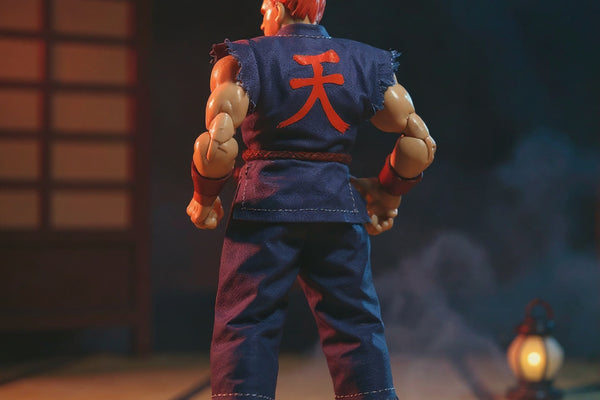 Tattered dark red and grey karate gi on action figure in dojo with dramatic lighting.