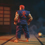 Tattered dark red and grey karate gi on action figure in dojo with dramatic lighting.