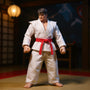 White karate gi cloth outfit with red belt wired in fighting stance displayed on dojo backdrop with wooden floor, training mat, and paper lantern.