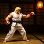 White 1/12 scale karate gi with red trim and cloth sash on headless figure mannequin in dojo with wooden floor, shoji screen, and dramatic red-black lighting.