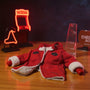 Red fabric military-style action figure jacket laid flat on a collector desk with miniature dojo backdrop and neon arcade signs.