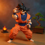 1/12 scale handmade Goku gi cloth outfit on an action figure with wooden dojo backdrop and blue energy effect