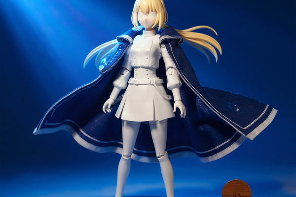 Deep blue and white 1/12 scale fabric cape with wire-frame folds draped on a faceless miniature mannequin, on a turntable with fantasy staff and wooden stand, against a bold blue-to-white gradient studio background.