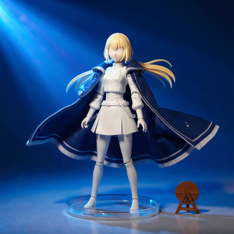 Deep blue and white 1/12 scale fabric cape with wire-frame folds draped on a faceless miniature mannequin, on a turntable with fantasy staff and wooden stand, against a bold blue-to-white gradient studio background.