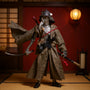 1/12 scale action figure wearing a dark fabric samurai robe, posed in a Japanese dojo setting with tatami, katana stand, and paper lantern, against a crimson and gold gradient background.