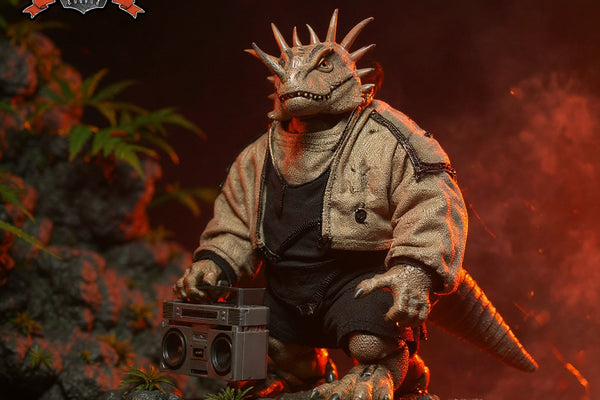 Ceratopsian dinosaur figure in textured fabric warrior outfit on rocky jungle diorama with dramatic side lighting.