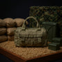 1/12 scale fabric tactical duffel bag with olive drab canvas texture on a sandbag barricade with camouflage netting and ammo crates, dramatic lighting, bold colors.